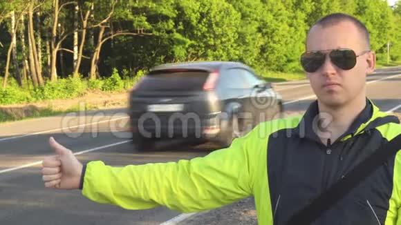 徒步旅行的年轻成年男子拇指指向州际公路视频的预览图