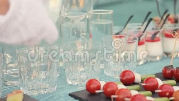 侍者在宴会上把水倒入玻璃杯中视频的预览图
