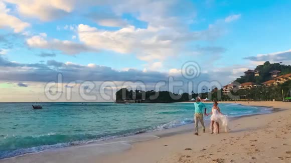 快乐的新娘和新郎在热带海滩上玩得开心我是玛瑞视频的预览图