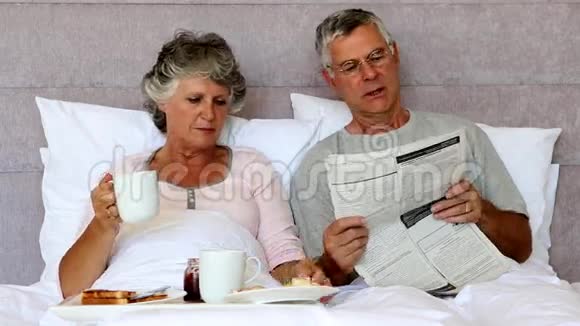 丈夫在早餐时给妻子看报纸视频的预览图