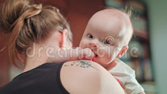 可爱的宝宝在妈妈的肩膀与拳头在嘴视频的预览图