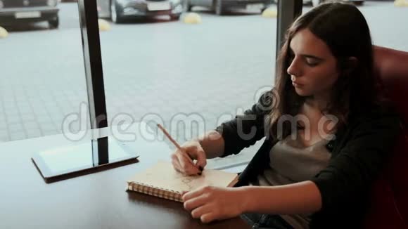 青少年学生在咖啡馆的笔记本上画草图视频的预览图