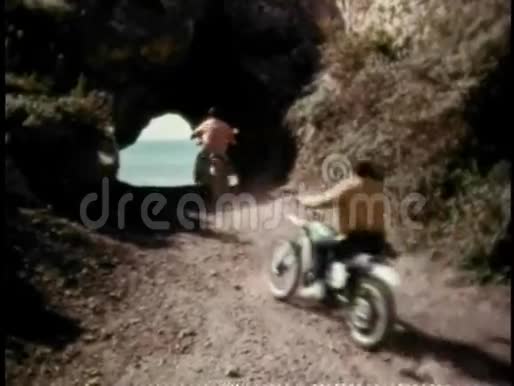 骑摩托车的男人穿过隧道来到海洋视频的预览图