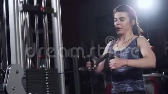 健身房里的女孩体重训练在背部的肌肉上工作在健身房锻炼划船的女人妇女视频的预览图