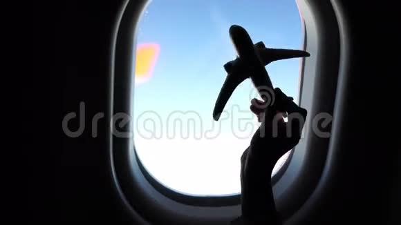 特写手举着飞机模型玩具背景窗视频的预览图