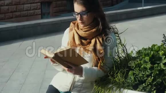 戴眼镜的年轻漂亮黑发女人在看书视频的预览图