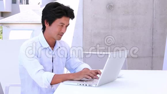 亚洲男人用笔记本电脑接电话视频的预览图