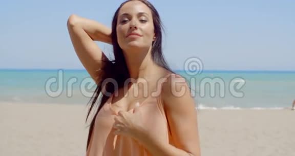 海滩上美丽的女士在镜头前微笑视频的预览图