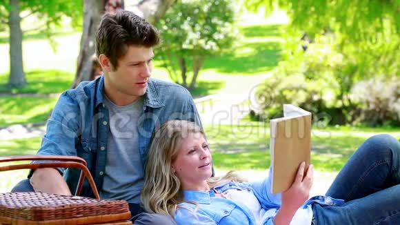 女人一边看书一边倚着丈夫视频的预览图