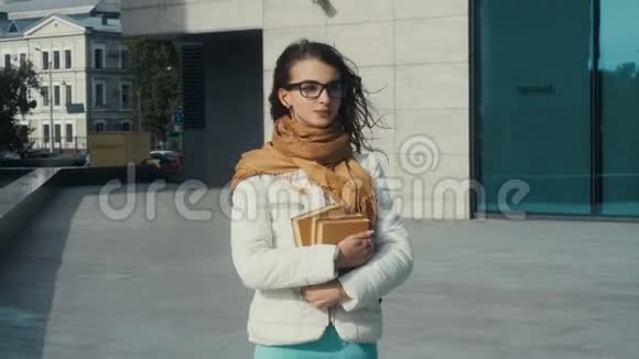 年轻的黑发女人戴着眼镜手里拿着书视频的预览图