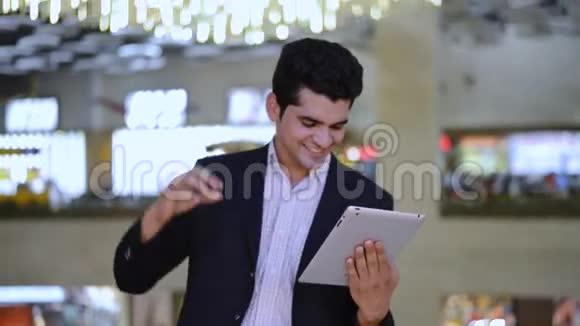 商人在看数字平板电脑时庆祝自己的成功视频的预览图