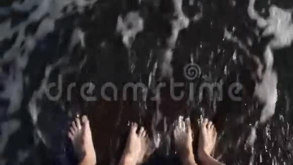 双脚两人被海浪冲刷俯视视频的预览图