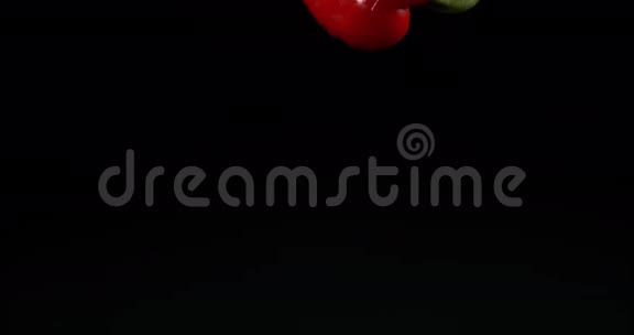 红辣椒辣椒蔬菜在黑色背景下落在水上视频的预览图