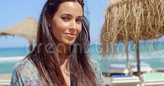 微笑的女士在海滩眺望远方视频的预览图