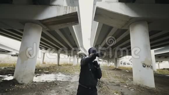 年轻的拳击手戴着耳机做拳击运动冬天在城市户外听音乐视频的预览图