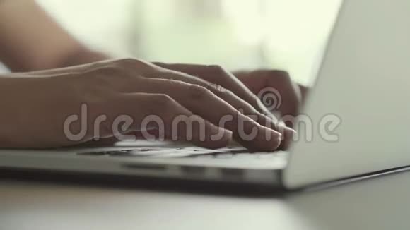 手在桌上的笔记本电脑键盘上工作和打字视频的预览图