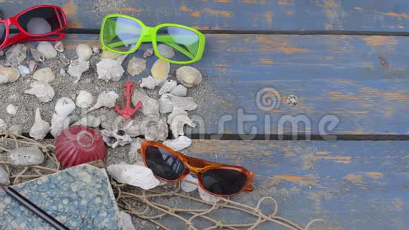 蓝色背景上的贝壳夏季旅行时间带各种贝壳太阳镜和海上度假背景视频的预览图