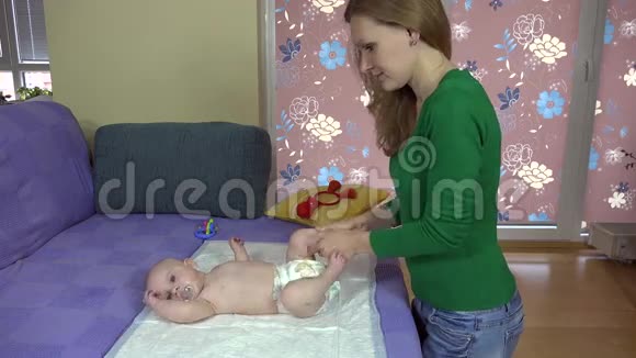 妈妈在床上按摩和锻炼小宝贝女儿的腿4K视频的预览图