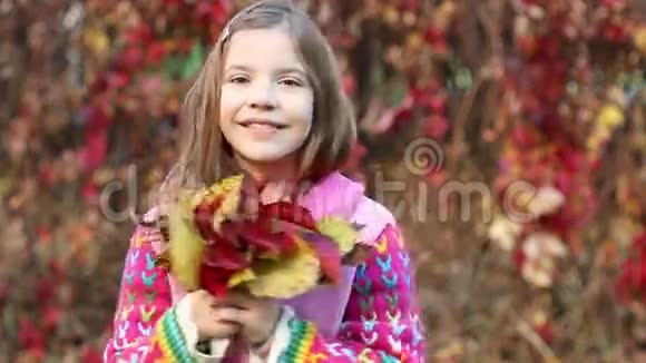 小女孩抱着五颜六色的叶子秋天视频的预览图