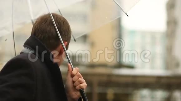 因天气而沮丧雨中站在伞下穿西装不开心的男人视频的预览图