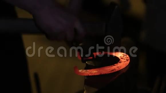 铁匠锻造马蹄铁一个铁匠在铁砧上敲打着炽热的马蹄铁铁匠拿着一个视频的预览图