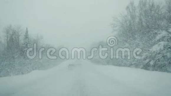 汽车行驶在雪道上在强烈的降雪在缓慢的运动1920x1080视频的预览图
