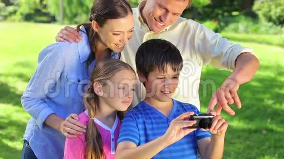微笑的家人用相机帮助小男孩视频的预览图