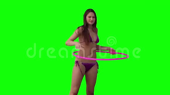 一个女人在旋转呼啦圈她的手臂举在头上视频的预览图