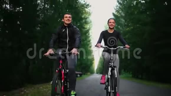 快乐的年轻夫妇男人和女人在大自然的夏天骑自行车视频的预览图