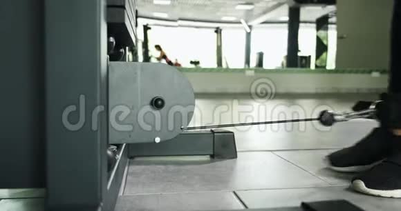 在体育俱乐部运动模拟器上训练肌肉的强壮漂亮的女人运动女性在健身机上做运动视频的预览图