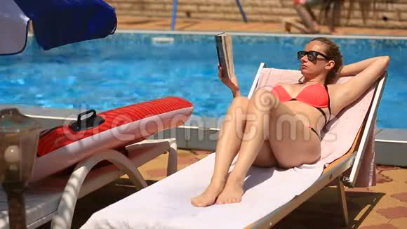 年轻优雅的女人在泳池边晒太阳视频的预览图