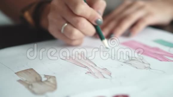 服装设计师用毛毡尖笔勾勒服装轮廓女性双手特写视频的预览图