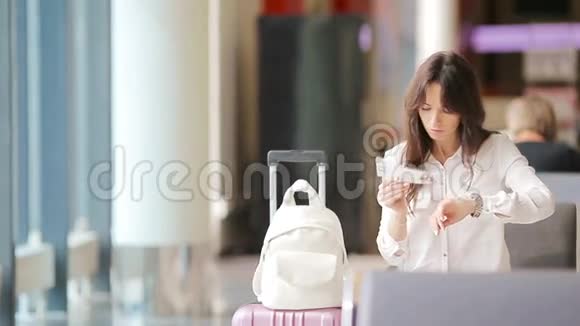 航空公司乘客在机场休息室等待航班飞机在候诊室找时间的白人女人视频的预览图