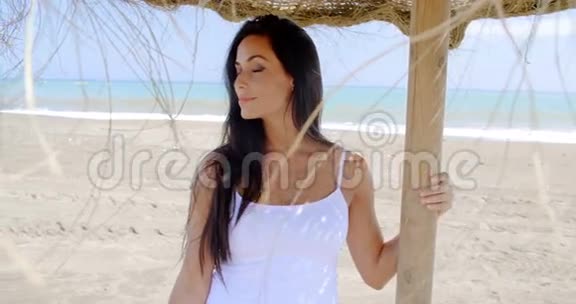 站在沙滩上遮阳伞的女人视频的预览图