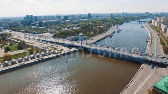 城市河流的鸟瞰图混凝土桥梁上的道路交通水中的船只视频的预览图