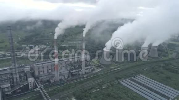 煤热电厂烟管和冷却塔的空中无人机视图热电站排汽视频的预览图