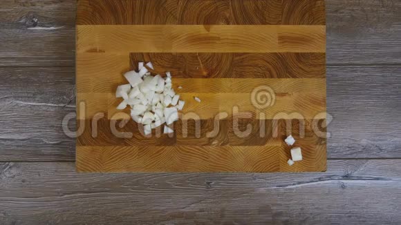 女性的手从木板上取下洋葱片视频的预览图