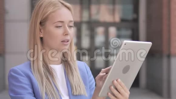 年轻的女商人在户外使用平板电脑视频的预览图