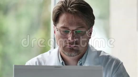严重男性医生在诊所使用电脑的画像视频的预览图