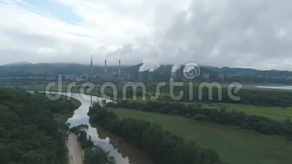煤热电厂烟管和冷却塔的空中无人机视图热电站排汽视频的预览图