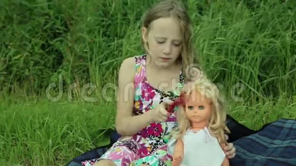 小女孩在外面草地上玩娃娃视频的预览图