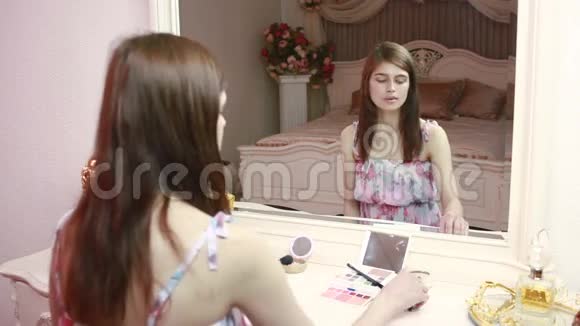 美女化妆美丽的女孩照镜子视频的预览图