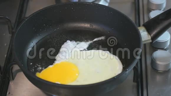 在平底锅里煎鸡蛋滑雪板站在滚刀上特写视频的预览图
