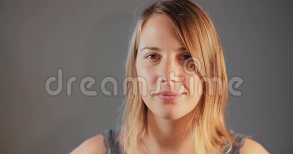 年轻的金发女子对着镜头眨眼视频的预览图