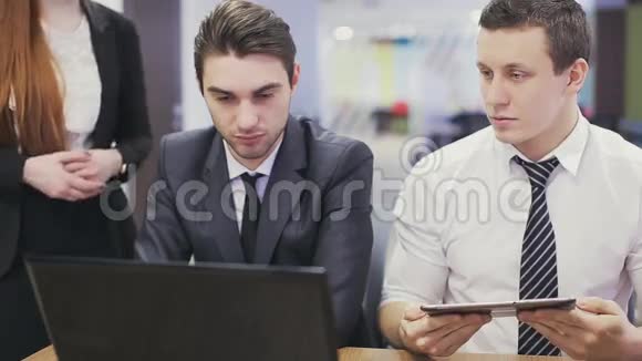 办公室工作人员在看手提电脑和讨论视频的预览图