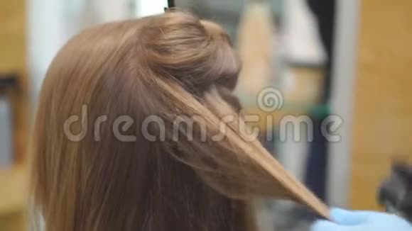 美发师在美女金发上做发型特写视频的预览图
