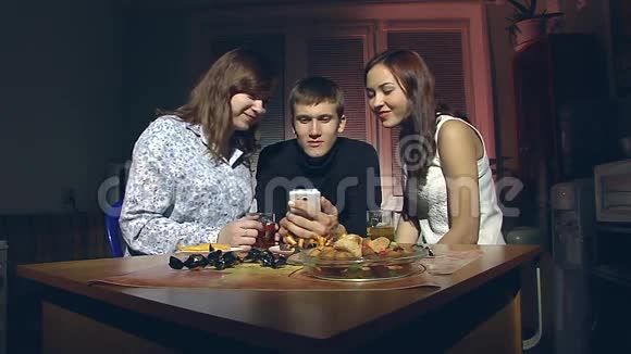 男人和两个女人看智能手机视频的预览图