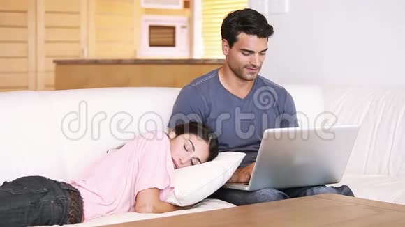 年轻人坐在女朋友旁边用笔记本电脑视频的预览图