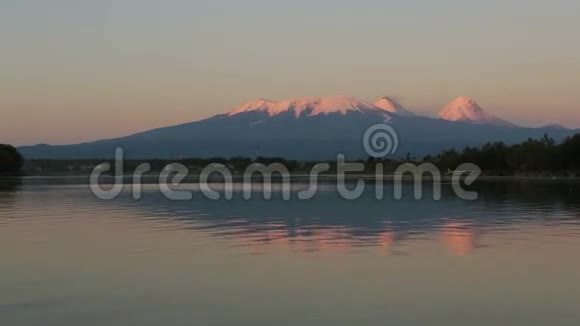 夕阳照亮了Kluchevskaya火山群在Kamchatka河上有倒影视频的预览图