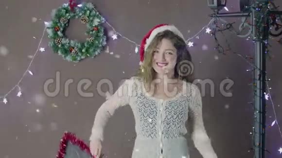 年轻漂亮可爱的女孩戴着圣诞帽微笑着手里拿着一个小黑板上面写着圣诞快乐视频的预览图